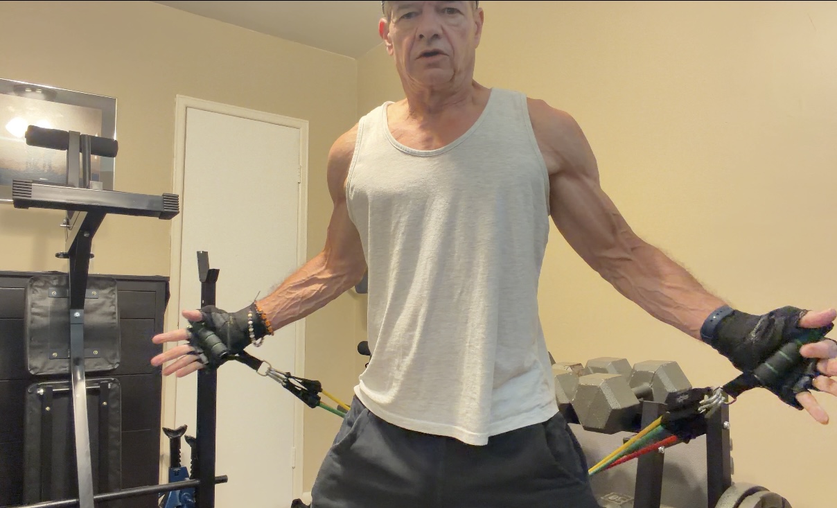John demonstrating the open-arm starting position of a resistance-band chest fly