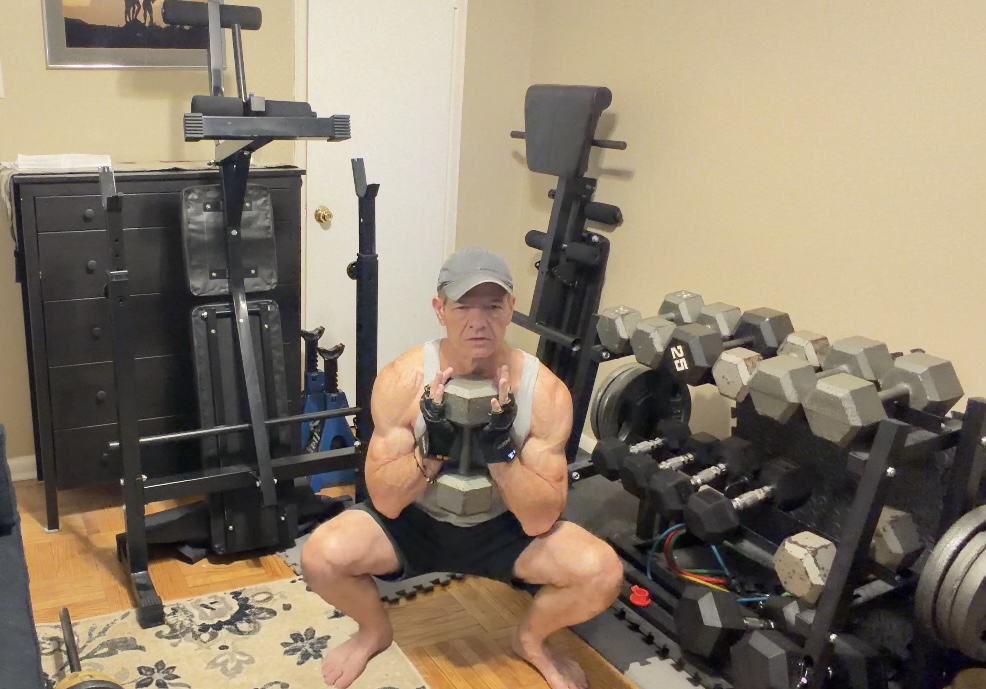John demonstrating a controlled deep goblet squat with his heels planted and knees tracking over his toes