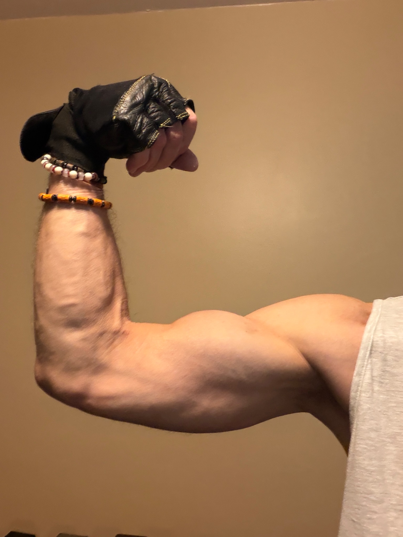 John flexing his arm at age 64 after years of consistent strength training