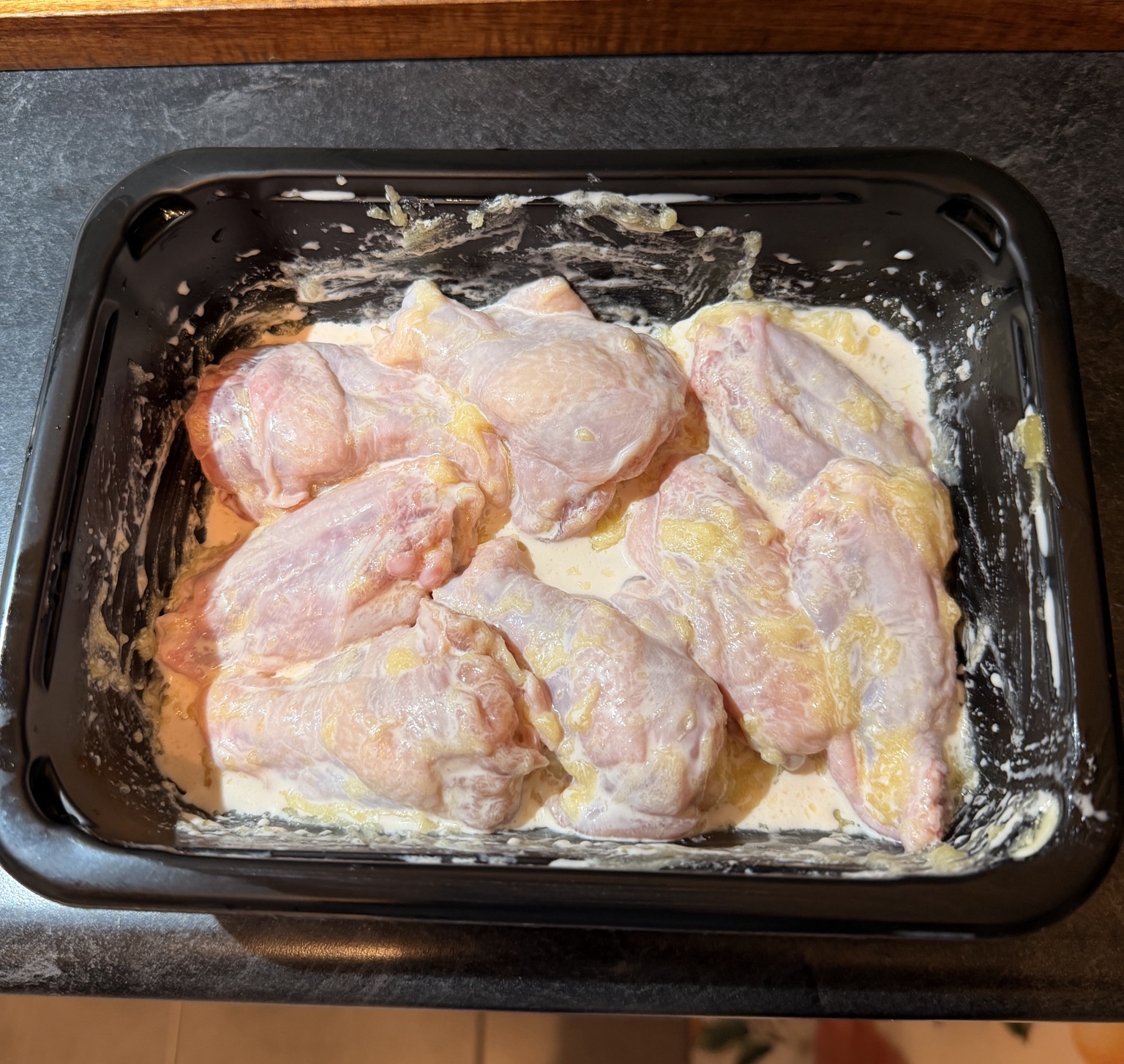 Raw chicken wings coated with heavy cream and melted ghee before baking